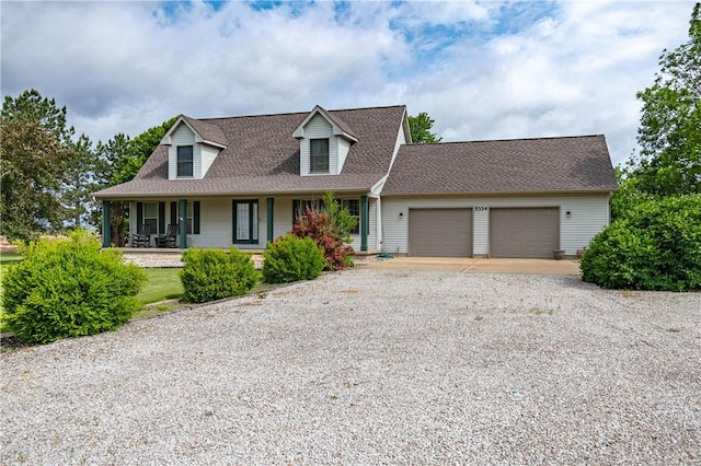 5334 Blue Mound Rd, Macon, IL 62544 - new england style home with gravel driveway, an attached garage, a porch, and a shingled roof