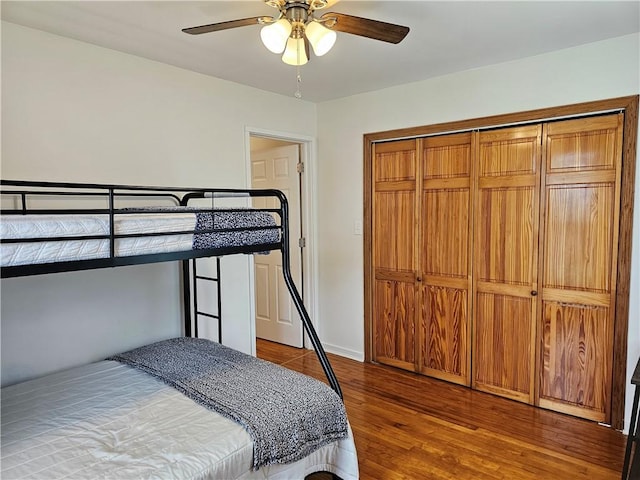 bedroom with wood finished floors, a ceiling fan, and a closet