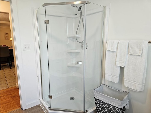 bathroom with a stall shower and wood finished floors