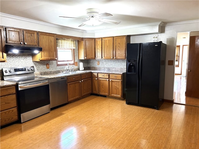 kitchen with a ceiling fan, under cabinet range hood, stainless steel appliances, backsplash, and ornamental molding