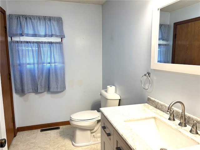bathroom featuring baseboards, visible vents, vanity, and toilet