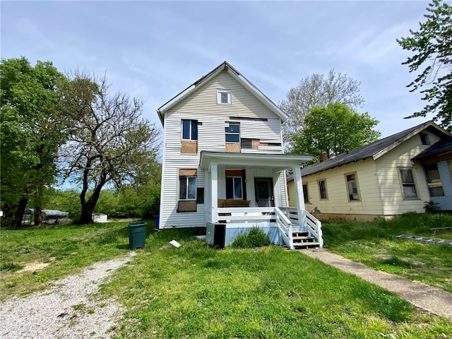 view of front of home featuring covered porch and a front yard