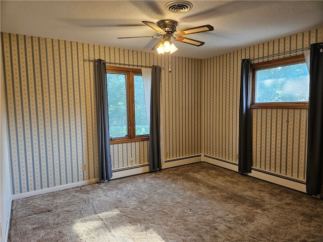 empty room with ceiling fan, plenty of natural light, and a textured ceiling