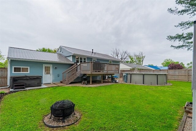 3531 Fontenac Dr, Decatur, IL 62521 - rear view of property with a fire pit, a wooden deck, a pool, stairs, and a hot tub