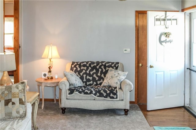 living area with baseboards and wood finished floors