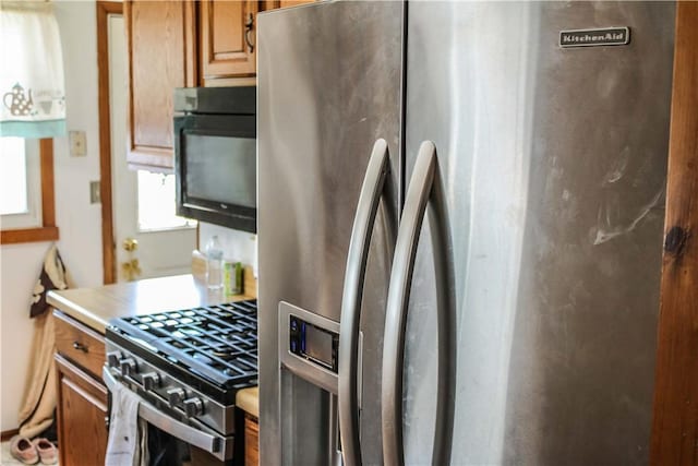 kitchen with brown cabinets, appliances with stainless steel finishes, and light countertops