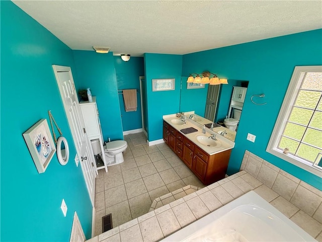 bathroom with a bath, toilet, tile patterned flooring, and a textured ceiling
