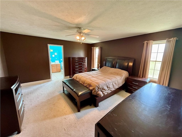 bedroom with a ceiling fan, carpet flooring, connected bathroom, and a textured ceiling