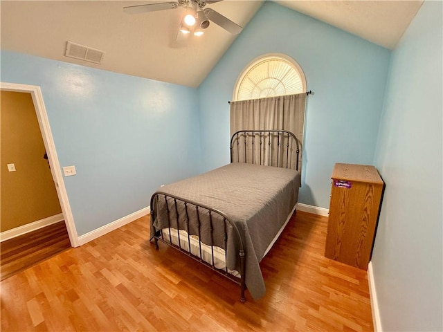 bedroom with vaulted ceiling, visible vents, baseboards, a ceiling fan, and wood finished floors