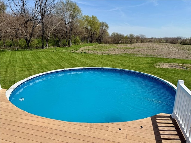 view of swimming pool with a yard