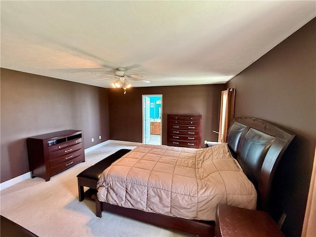 carpeted bedroom featuring ceiling fan, baseboards, and connected bathroom