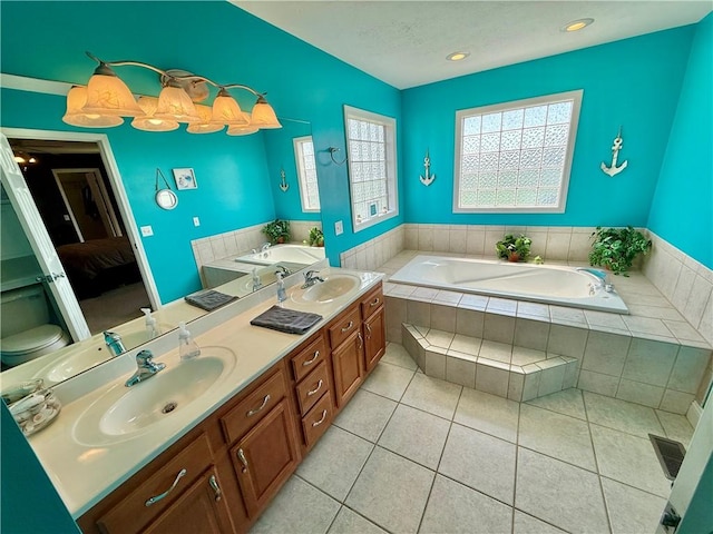bathroom featuring a garden tub, double vanity, and a sink