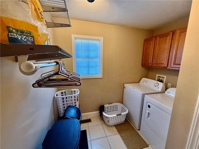 laundry area featuring cabinet space, baseboards, washing machine and dryer, and light tile patterned flooring