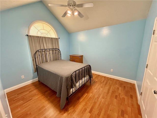 bedroom featuring lofted ceiling, baseboards, and wood finished floors