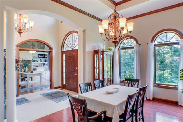 6086 Chicory Knl, Charleston, IL 61920 - dining area featuring a chandelier, arched walkways, healthy amount of natural light, crown molding, and wood finished floors
