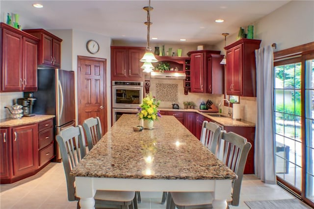 6086 Chicory Knl, Charleston, IL 61920 - kitchen featuring stainless steel appliances, reddish brown cabinets, tasteful backsplash, pendant lighting, and recessed lighting