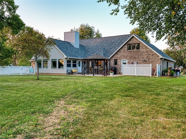 rear view of property with a lawn and a patio