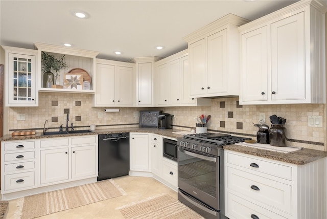 kitchen featuring dark stone countertops, sink, appliances with stainless steel finishes, and tasteful backsplash