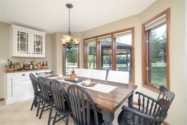 dining area featuring a chandelier, light tile patterned floors, and bar area