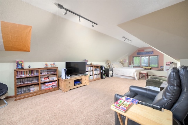 carpeted bedroom featuring lofted ceiling and rail lighting