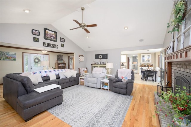 living room featuring ceiling fan, wood-type flooring, and vaulted ceiling