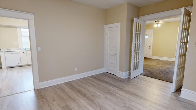 empty room with french doors and light hardwood / wood-style flooring