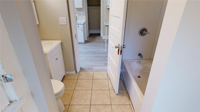 bathroom featuring vanity, hardwood / wood-style flooring, toilet, and a tub