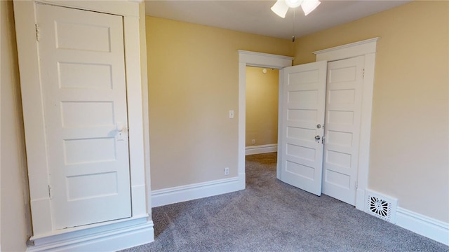 unfurnished bedroom featuring dark colored carpet and ceiling fan