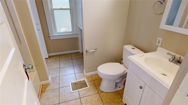 bathroom featuring tile patterned floors, a tub, vanity, and toilet