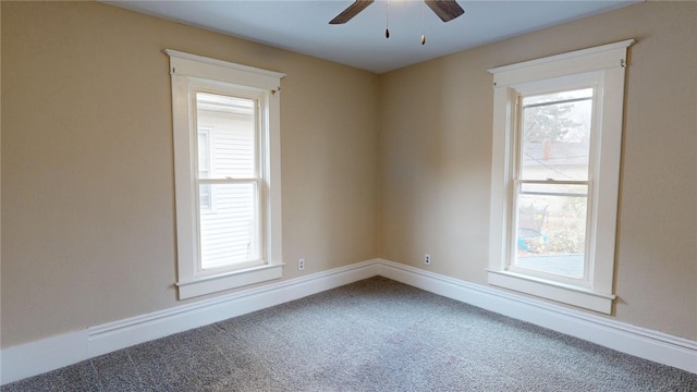 carpeted spare room with plenty of natural light and ceiling fan