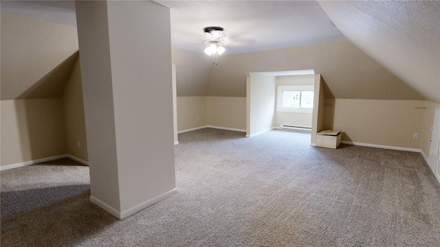 additional living space featuring carpet, lofted ceiling, a textured ceiling, and a baseboard heating unit