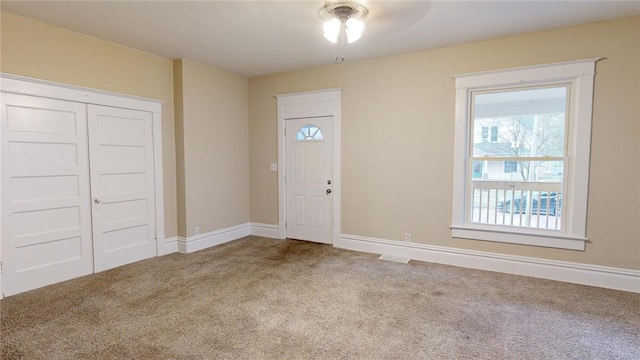 carpeted entryway with ceiling fan