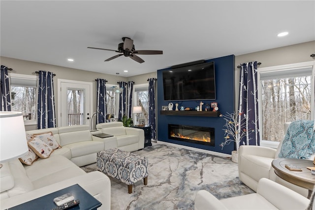 living room with ceiling fan and a large fireplace