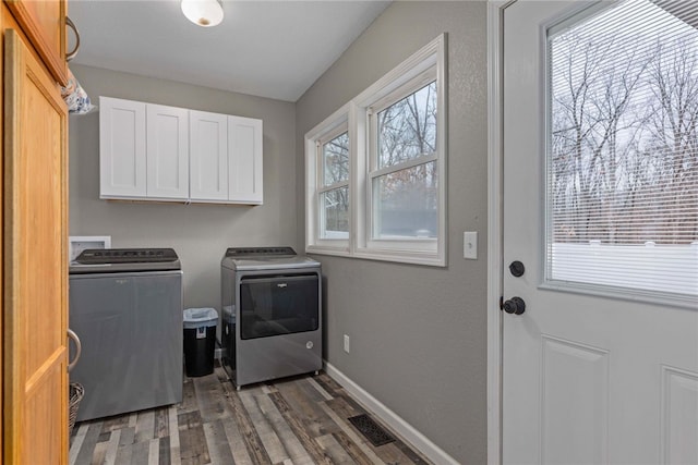 laundry area with cabinets, dark hardwood / wood-style flooring, and washer and dryer