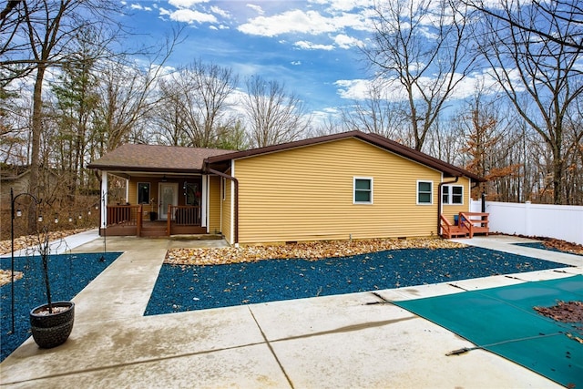 rear view of property with a covered pool and a patio area