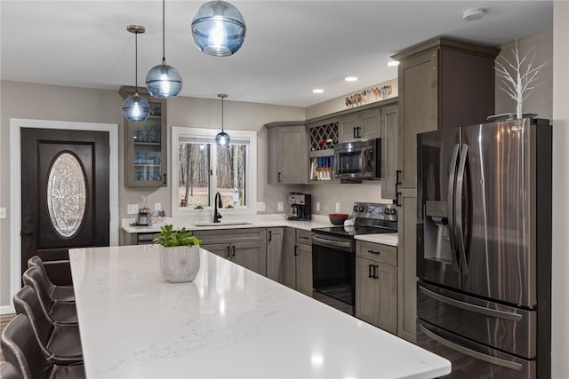 kitchen featuring pendant lighting, sink, a kitchen breakfast bar, and appliances with stainless steel finishes