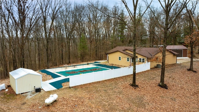 view of pool with cooling unit and a storage shed