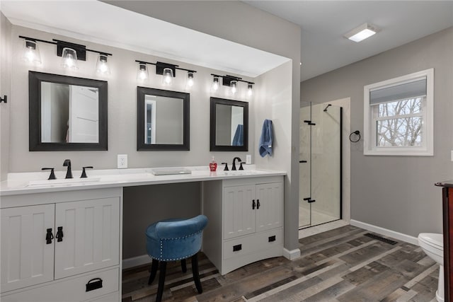 bathroom featuring hardwood / wood-style flooring, vanity, toilet, and walk in shower