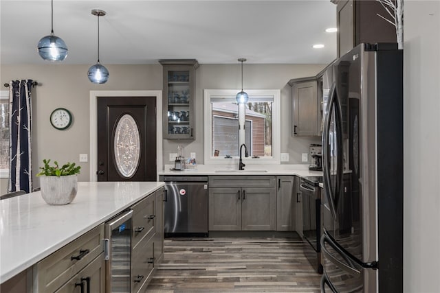 kitchen featuring sink, fridge, decorative light fixtures, stainless steel dishwasher, and beverage cooler