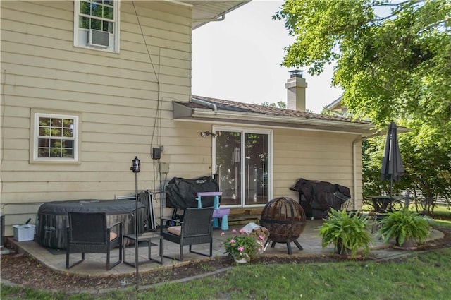 317 Hickory Ln, Mattoon, IL 61938 - back of property featuring a patio area, a chimney, and a hot tub