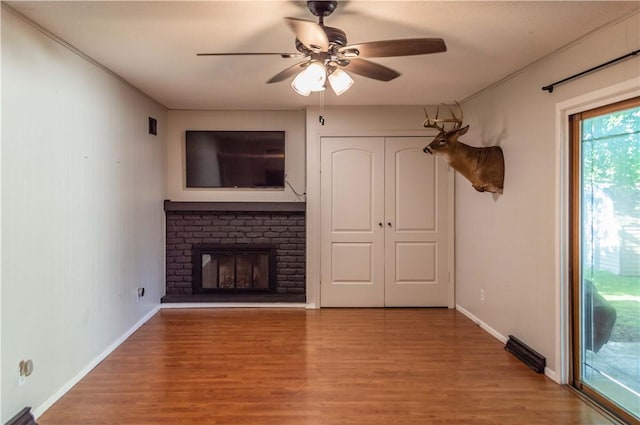 317 Hickory Ln, Mattoon, IL 61938 - unfurnished living room featuring ceiling fan, light wood finished floors, and a brick fireplace