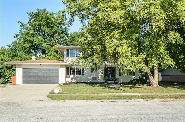 317 Hickory Ln, Mattoon, IL 61938 - obstructed view of property with concrete driveway, a garage, and a front lawn