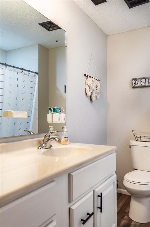 317 Hickory Ln, Mattoon, IL 61938 - bathroom with a textured ceiling, vanity, wood finished floors, and curtained shower