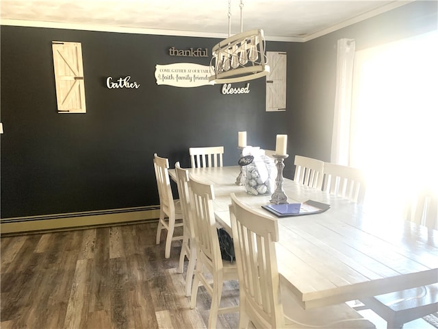 dining room featuring baseboard heating, ornamental molding, and wood-type flooring