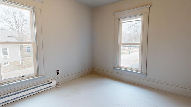 unfurnished room with baseboard heating and a healthy amount of sunlight