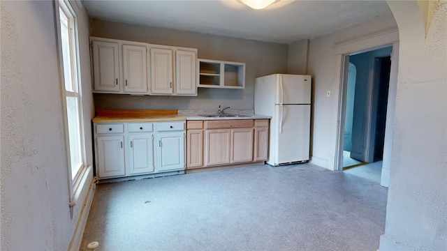 kitchen featuring white refrigerator, sink, and a wealth of natural light