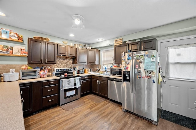 22417 N 1320th St, Marshall, IL 62441 - kitchen featuring stainless steel appliances, light countertops, dark brown cabinetry, light wood-type flooring, and backsplash