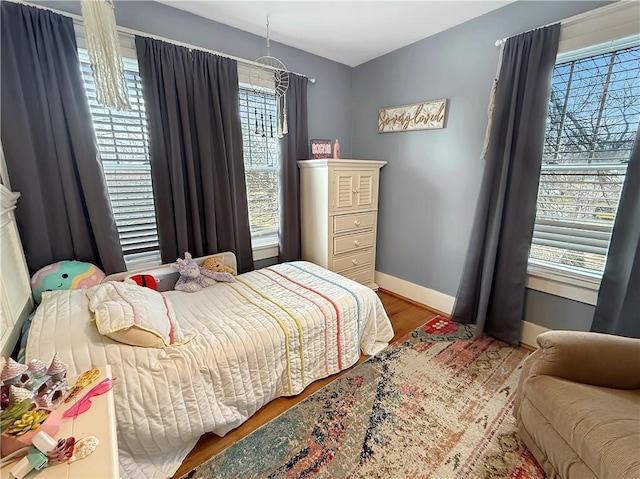 bedroom with baseboards and wood finished floors