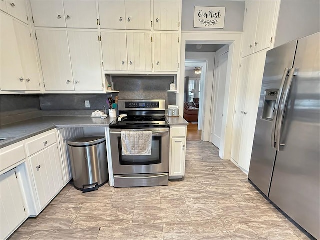 kitchen featuring dark countertops, appliances with stainless steel finishes, and backsplash