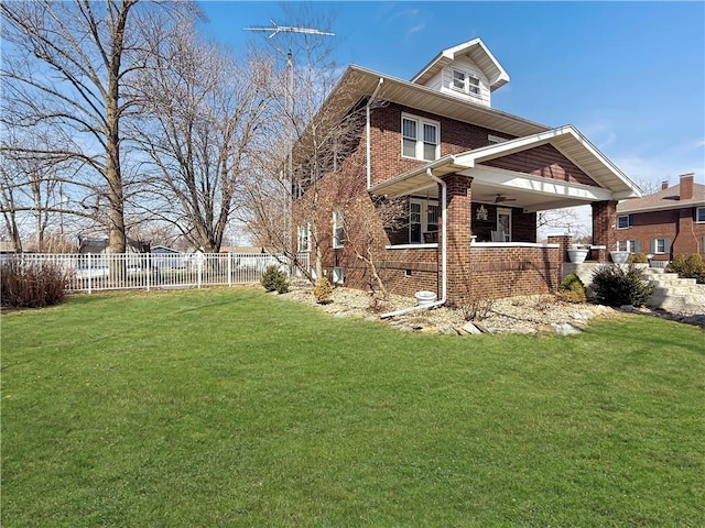 view of home's exterior with a yard, brick siding, and fence